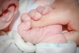 Image: newborn holding parent's hand